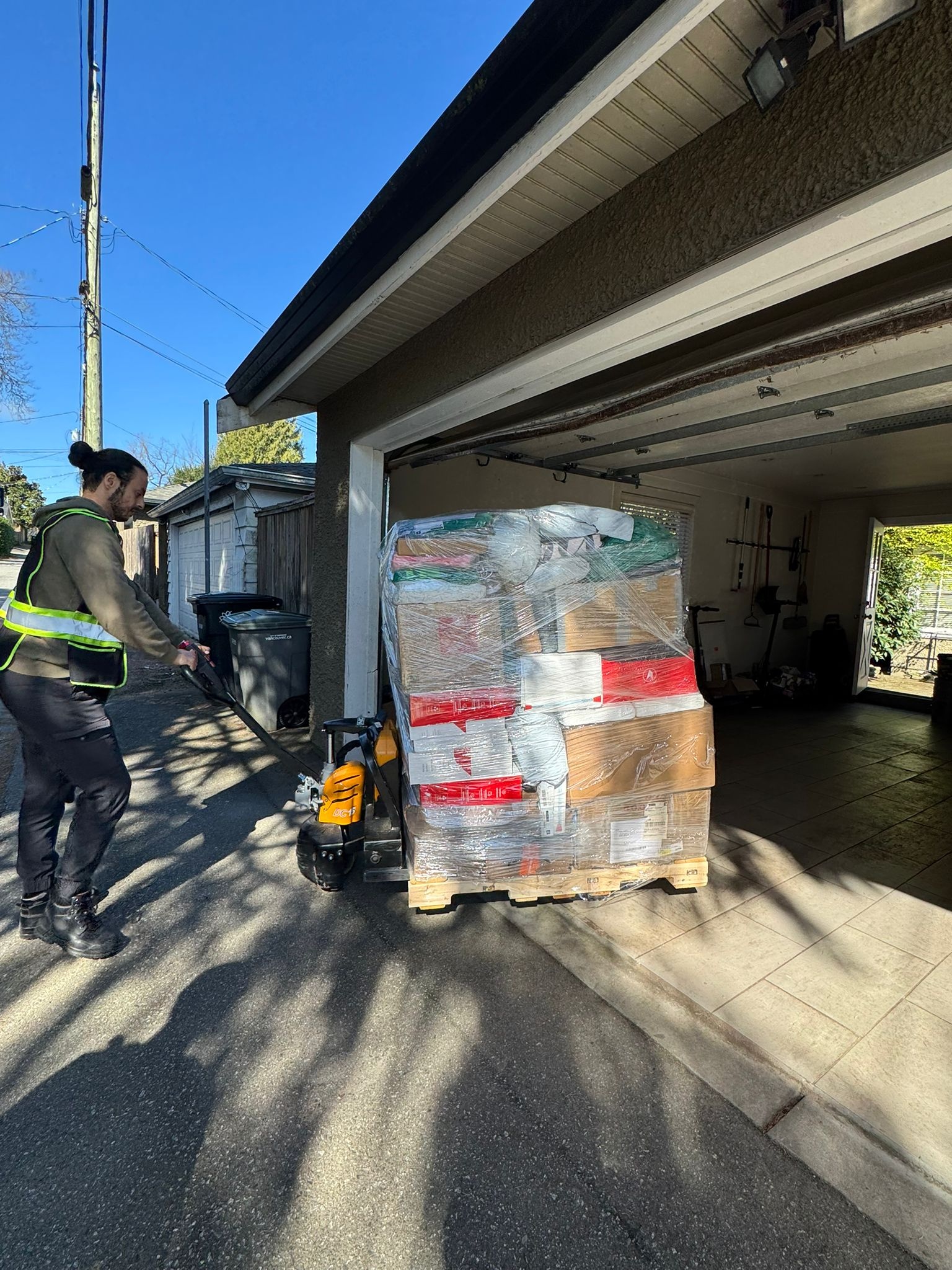 April 2026 Delivery - Worker pushing wrapped pallet into garage entrance