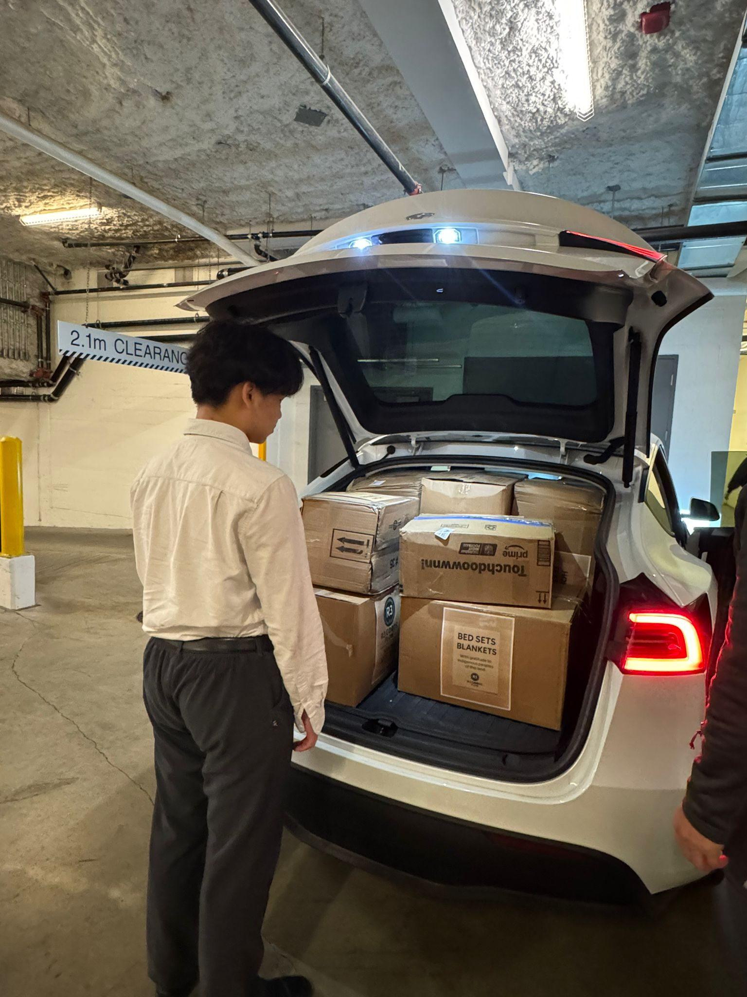 Post-Easter 2026 - Volunteer loading boxes into car trunk in underground parking