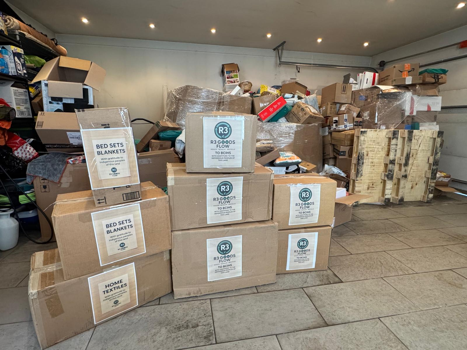 Post-Easter 2026 - Wide view of sorted donation boxes with unsorted goods in background