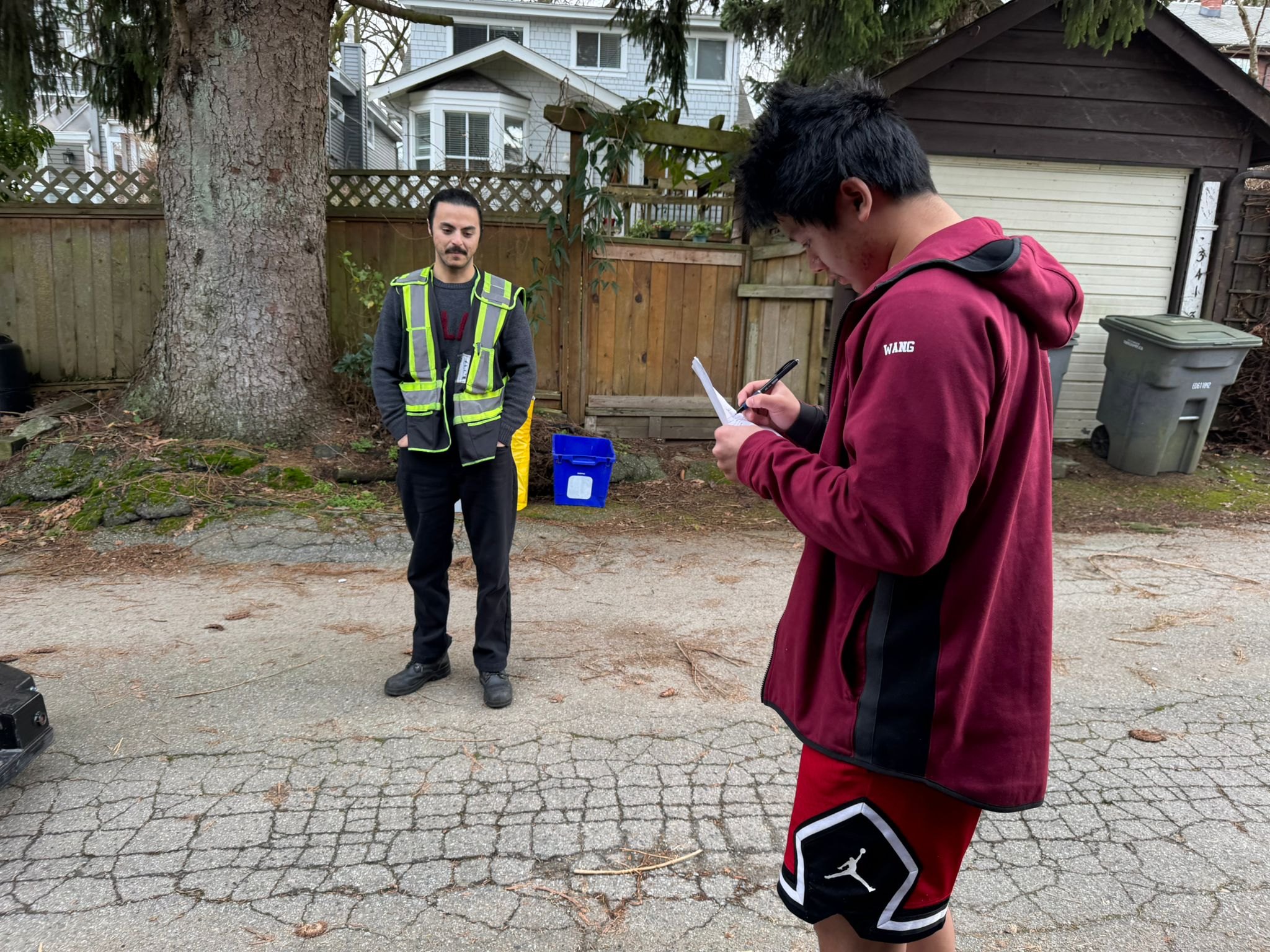 Heading into 2026 Batch - R3 team member taking notes while delivery worker reviews documents