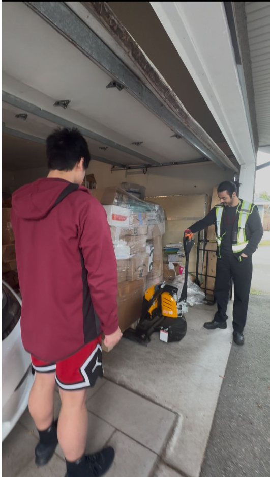 Heading into 2026 Batch - R3 team members receiving pallet in garage