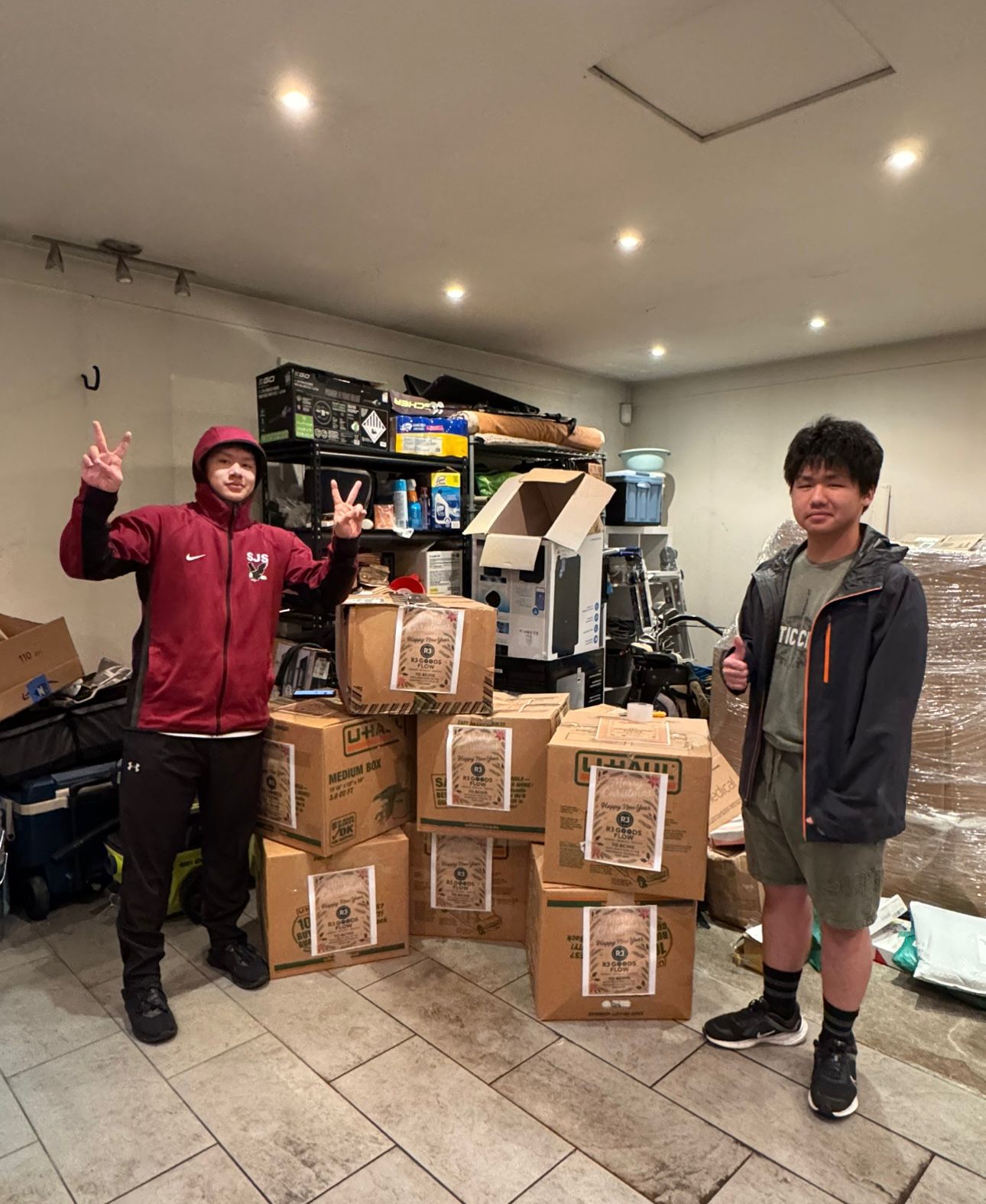 Approaching Christmas 2025 - Two volunteers in garage with victory signs