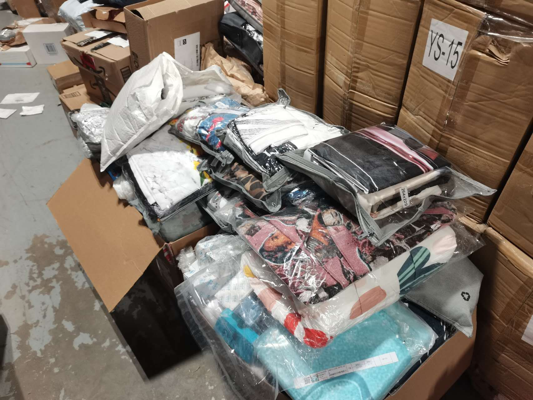 Sorted donation items including bedding, blankets, and household goods ready for processing