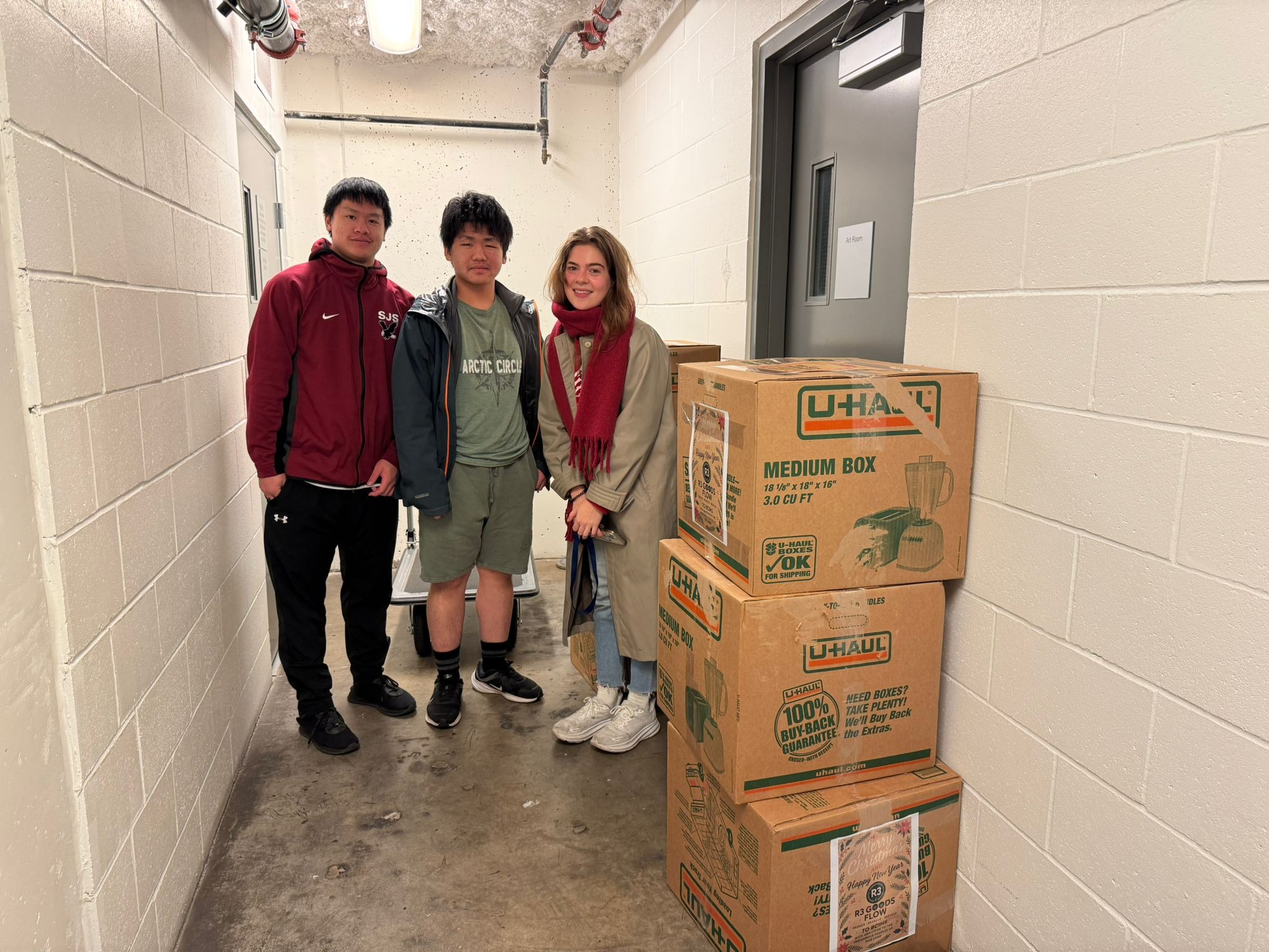 Young volunteers with U-Haul donation boxes ready for delivery